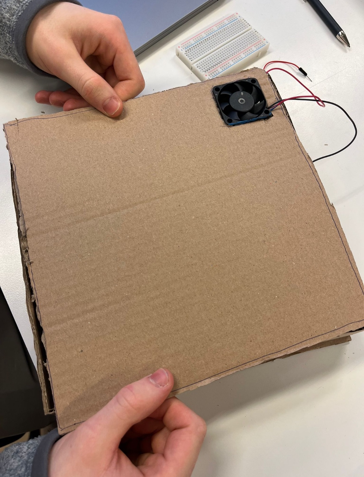 Early cardboard prototype of the journaling box with fan cutout