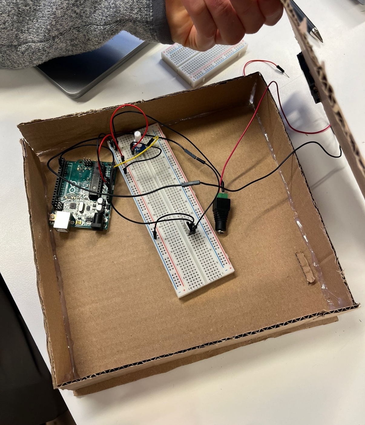 Inside of the cardboard prototype showing Arduino, breadboard, and wiring